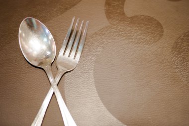 kahverengi doku üzerinde bıçak ve çatal