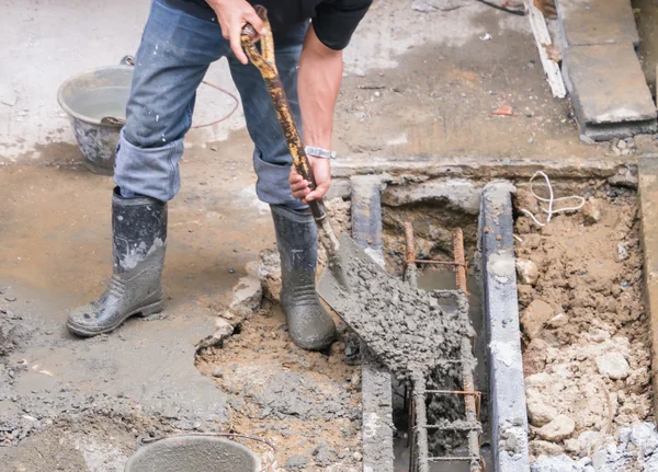 Worker hand holding shovel in construction area — Stock Photo, Image