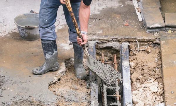 Robotnik ręka trzyma łopata na terenie budowy — Zdjęcie stockowe