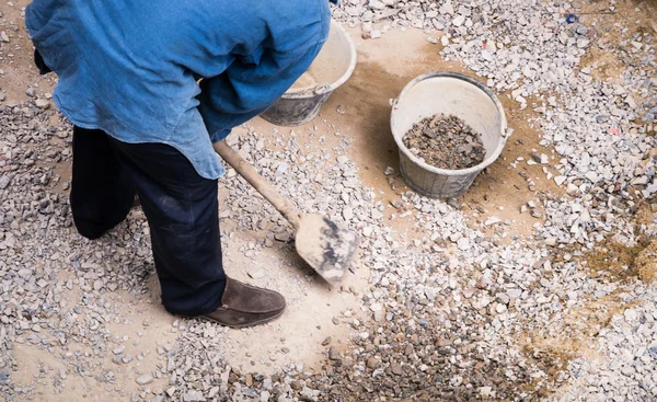 Werknemer verzamelen steen — Stockfoto