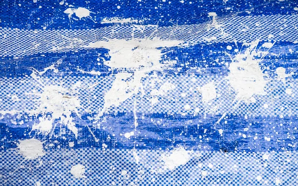 Witte verf op blauw plastic folie — Stockfoto