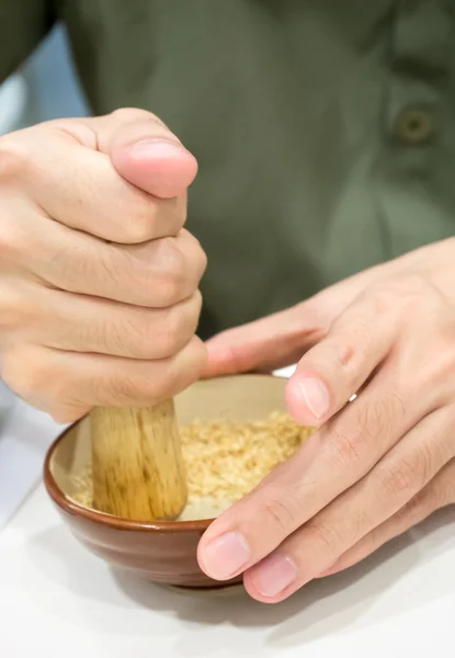 Ręka, walenie białego sezamu — Zdjęcie stockowe