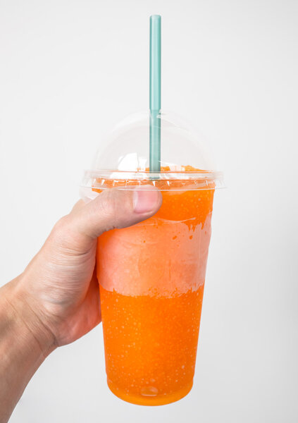 Hand holding orange soft drink