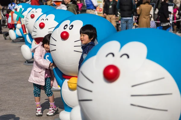 Niños toma foto con la figura de Doraemon — Foto de Stock