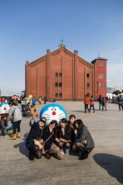 Girls take photo with Doraemon figure — Stock Photo, Image