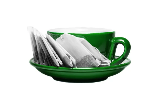 Green cup and plate with teabags — Stock Photo, Image