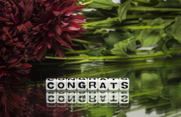 Congrats with red flowers and green leaves — Stock Photo, Image