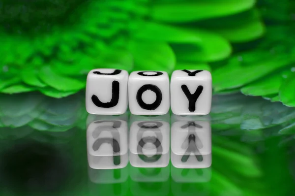 Радостный текст с зелеными цветами — стоковое фото