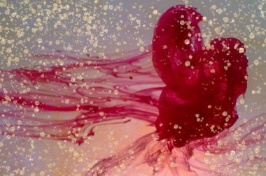 Su ve altın tozu içinde yüzen kırmızı mürekkep ve damlalar alkol sıvısı üzerine dökülür soyut doku sıvısı sanat ile altın parıltısı ve gölgeli sıvı.