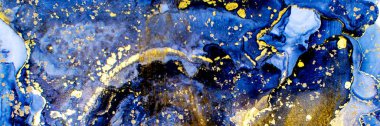 Golden dust and drops on dark blue Alcohol ink fluid abstract texture fluid art with gold glitter and liquid with shades.