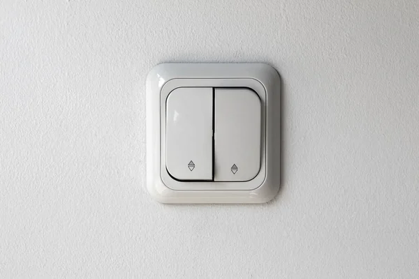 Light switch panel, white color on white wall, front view