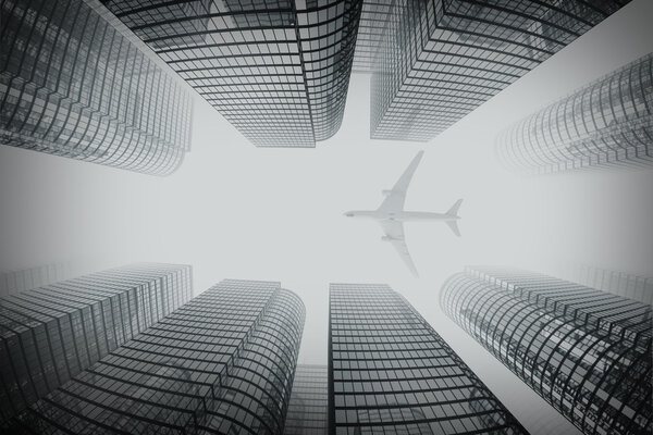 Shot of airplane flying above glass office buildings in fog. Fisheye lens effect.