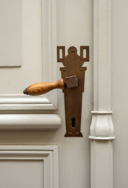 Pirinçten kapı kolu olan eski ahşap bir kapı..