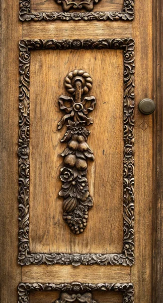 Detalle de puerta tallada en madera. Decoración tallada en forma de hojas y frutas. Marco tallado —  Fotos de Stock