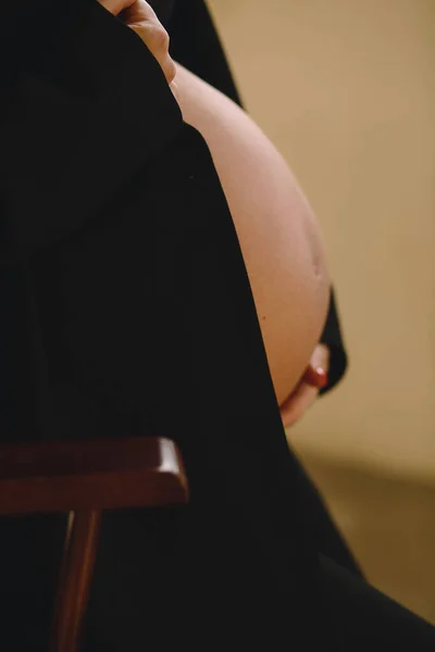 一张怀孕的腹部的近照 穿着黑色夹克的孕妇抱着她的肚子 爱的概念 祝你怀孕愉快父母之职 — 图库照片