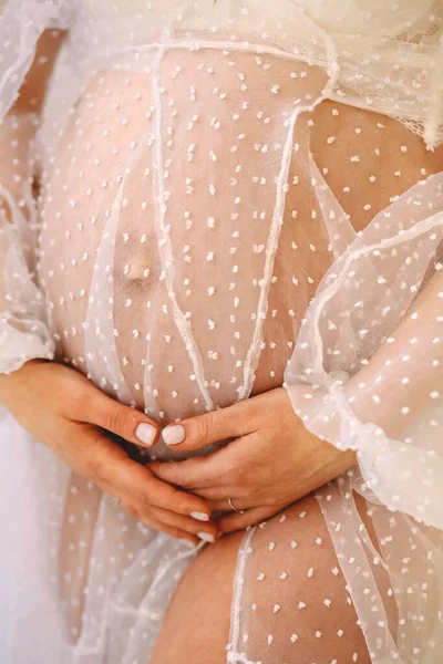 一张怀孕的腹部的近照 穿着白色皮衣的孕妇抱着她的肚子 爱的概念 祝你怀孕愉快 — 图库照片