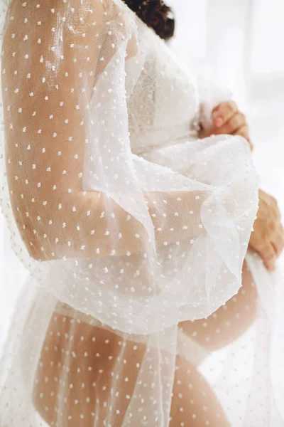 孕妇腹部的近照 穿着白色皮衣的孕妇抱着她的肚子 爱的概念 祝你怀孕愉快 — 图库照片