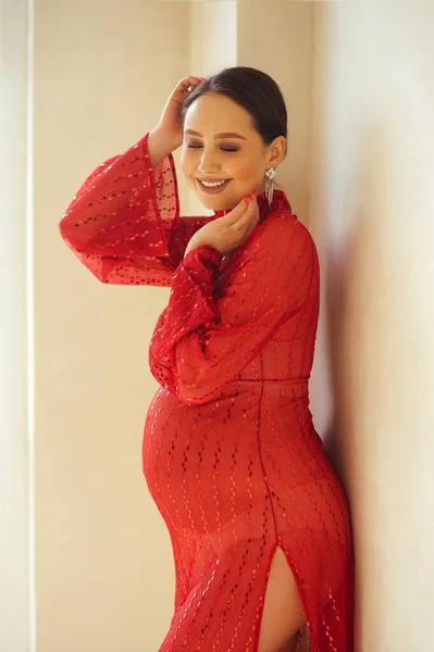 Portret Atrakcyjnej Kobiety Ciąży Pięknej Błyszczącej Czerwonej Sukience Stojącej Przy — Zdjęcie stockowe