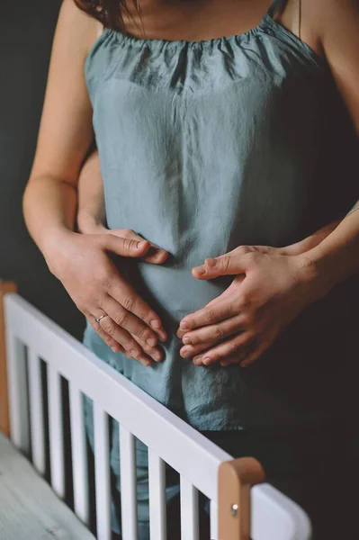 Pregnant Woman Blue Pajamas Her Husband Standing Crib Holding Hands — ストック写真