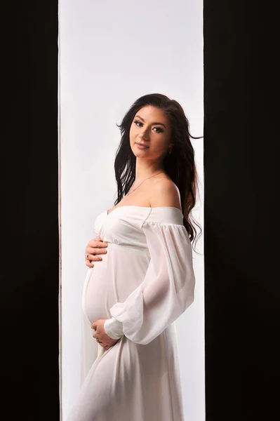 Piękna Kobieta Ciąży Białej Sukience Trzymając Jej Brzucha Ciąży Izolowane — Zdjęcie stockowe