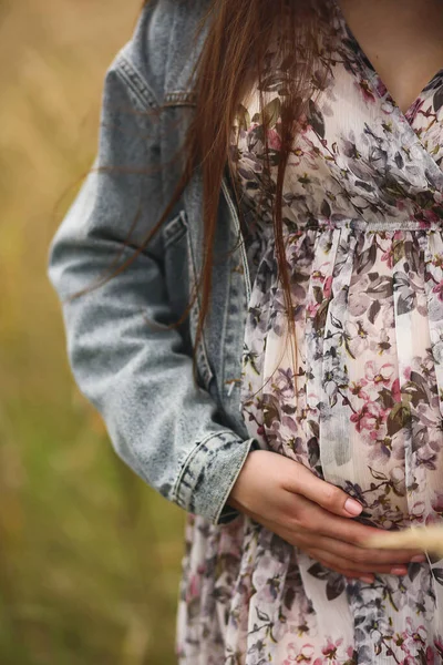 穿着华丽华丽衣服和斜纹棉布夹克的孕妇用她的手触摸着她怀孕的腹部 快乐的母亲和父母的概念 文本的复制空间 — 图库照片