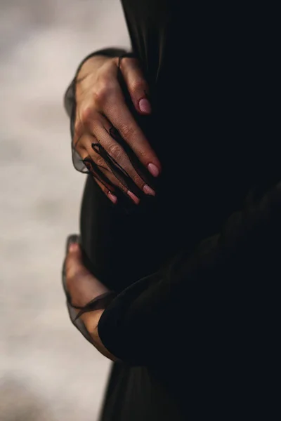 穿着黑色衣服和黑色郁金香手套的孕妇抱着她的腹部 并留有抄写的空间 爱的概念 怀孕22周祝你怀孕愉快 — 图库照片