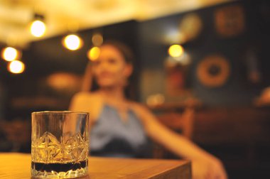  Bulanık, neşeli bir kız geçmişinde bir bardak viski. Parti zamanı. Kutlama