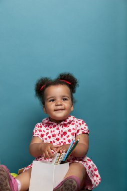 defter ve kalem ile oturan kız