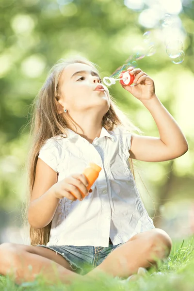 Menina está soprando sabão — Fotografia de Stock