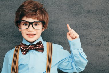 neşeli küçük öğrenci kara tahta karşı