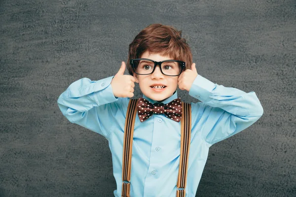 Fröhlicher kleiner Schüler gegen Kreidetafel — Stockfoto