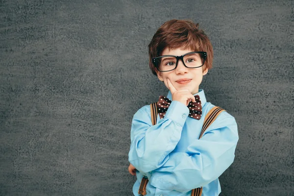 Fröhlicher kleiner Schüler gegen Kreidetafel — Stockfoto