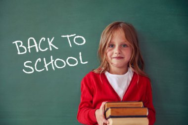 Okul çocuğu (kız) sınıfta. Yeşil karatahtaya karşı komik çocuk. Fikir ve yaratıcılık kavramı. Arka planda kopyalanma alanı. Okul konseptine dönelim.. 