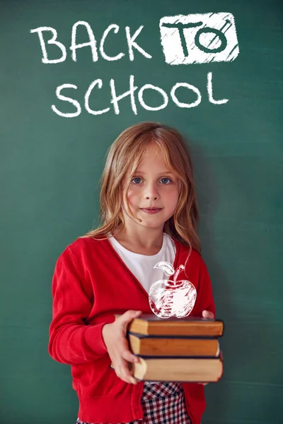 School child (girl) in classroom. Funny kid against green chalkboard. Idea and creativity concept. Copyspace on background. Back to school concept.