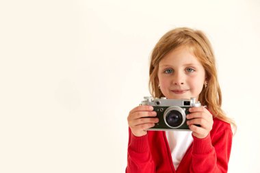 Güzel gülümseyen çocuk (çocuk, kız) elinde bir kamera tutuyor. Fotoğraf ve reklam kavramını öğren