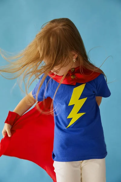 穿着红色雨衣的可爱的超级英雄小孩 蓝色背景的有趣的孩子 观念和创造力概念 — 图库照片
