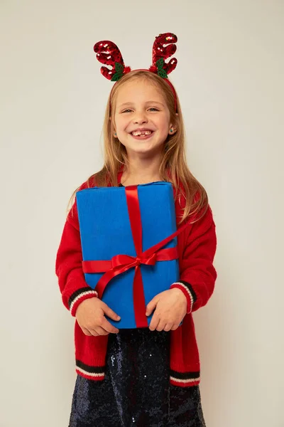 Glimlachend Grappig Kind Kind Meisje Rendier Haarband Met Kerstcadeaus Hand Rechtenvrije Stockafbeeldingen