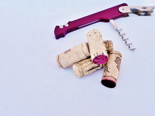 A corkscrew with wine corks. — Stock Photo, Image