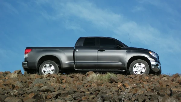 Camioneta gris en un camino rocoso . — Foto de Stock