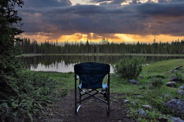 Empty Camping Chair Sitting Bank Calm Mountain Lake Gorgeous Sunset — Foto Stock