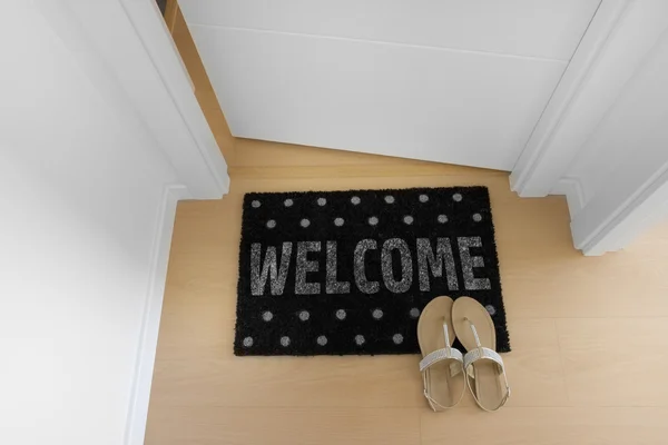 Welcome home doormat with open door — Stock Photo © OSORIOartist #25153739
