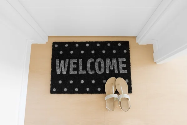 Bienvenido a casa en alfombra negra — Foto de Stock