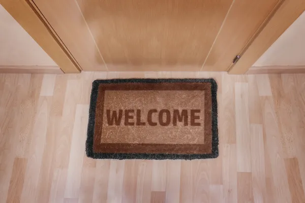 Welcome home doormat with closed door — Stock Photo, Image