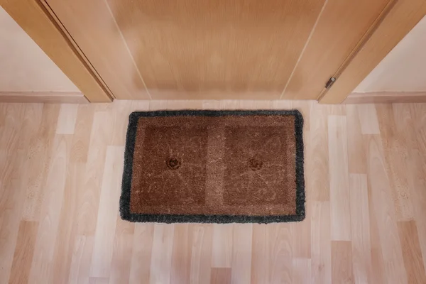 Welcome home doormat with closed door — Stock Photo, Image