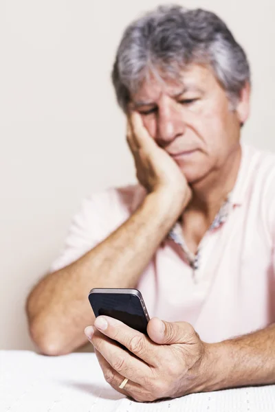 Smartphone and senior man at home — Stock Photo, Image