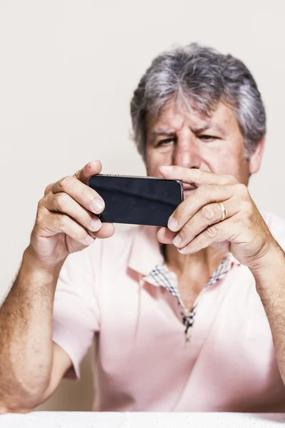 Smartphone and senior man at home — Stock Photo, Image
