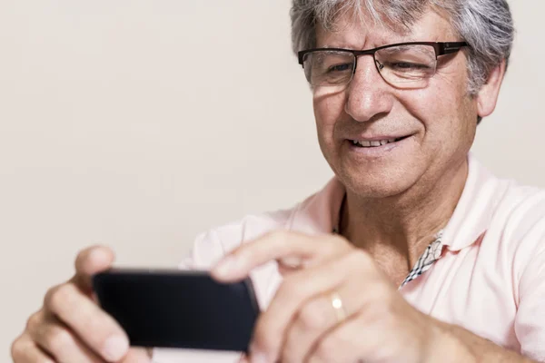 Smartphone and senior man at home — Stock Photo, Image