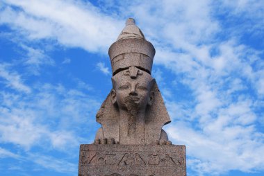 Mavi gökyüzüne karşı taştan yapılmış Mısır sfenksi.