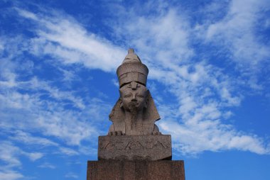 Mavi gökyüzüne karşı taştan yapılmış Mısır sfenksi.