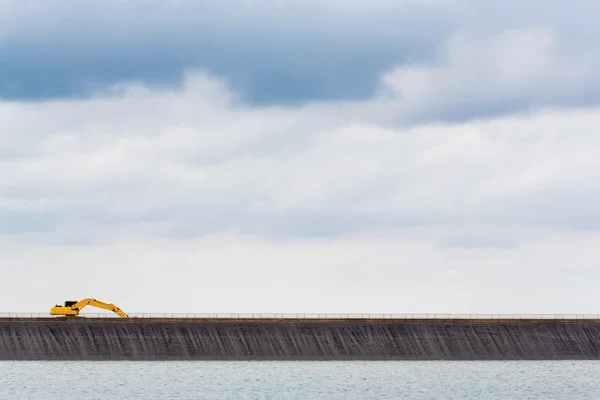 Backhoe na crista da barragem — Fotografia de Stock